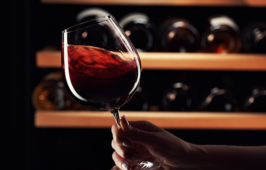 Рука с красным вином. Сомелье